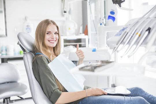 Vrouw in tandartsstoel heeft geen angst voor de tandarts